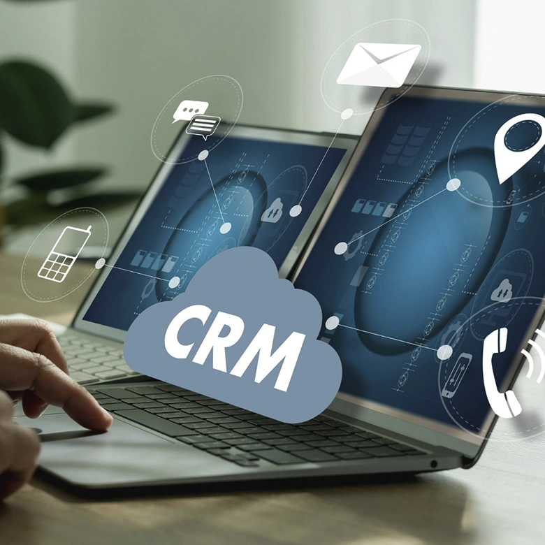 hombre tecleando portátil con letras CRM